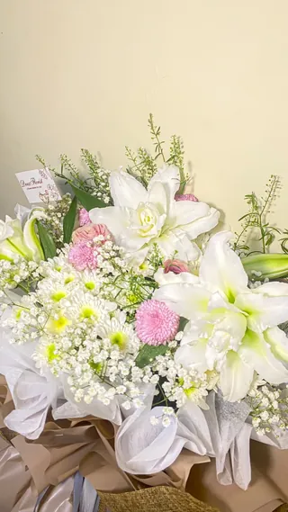 Ivory Lily: Lily putih, aster pink, baby breath, pompom ungu, daun thlaspi dengan wrapping coklat mix goni