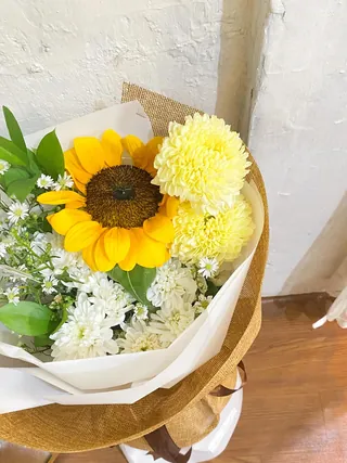 Soleil Sunflower: Bunga matahari, gompie putih salmon, aster putih, daun ruskus dan pikok putih, wrapping goni